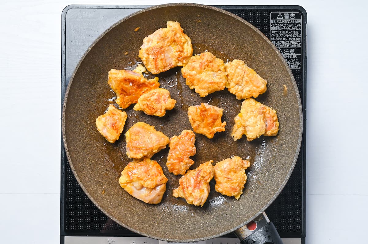 Chicken thigh with fluffy egg batter in a frying pan