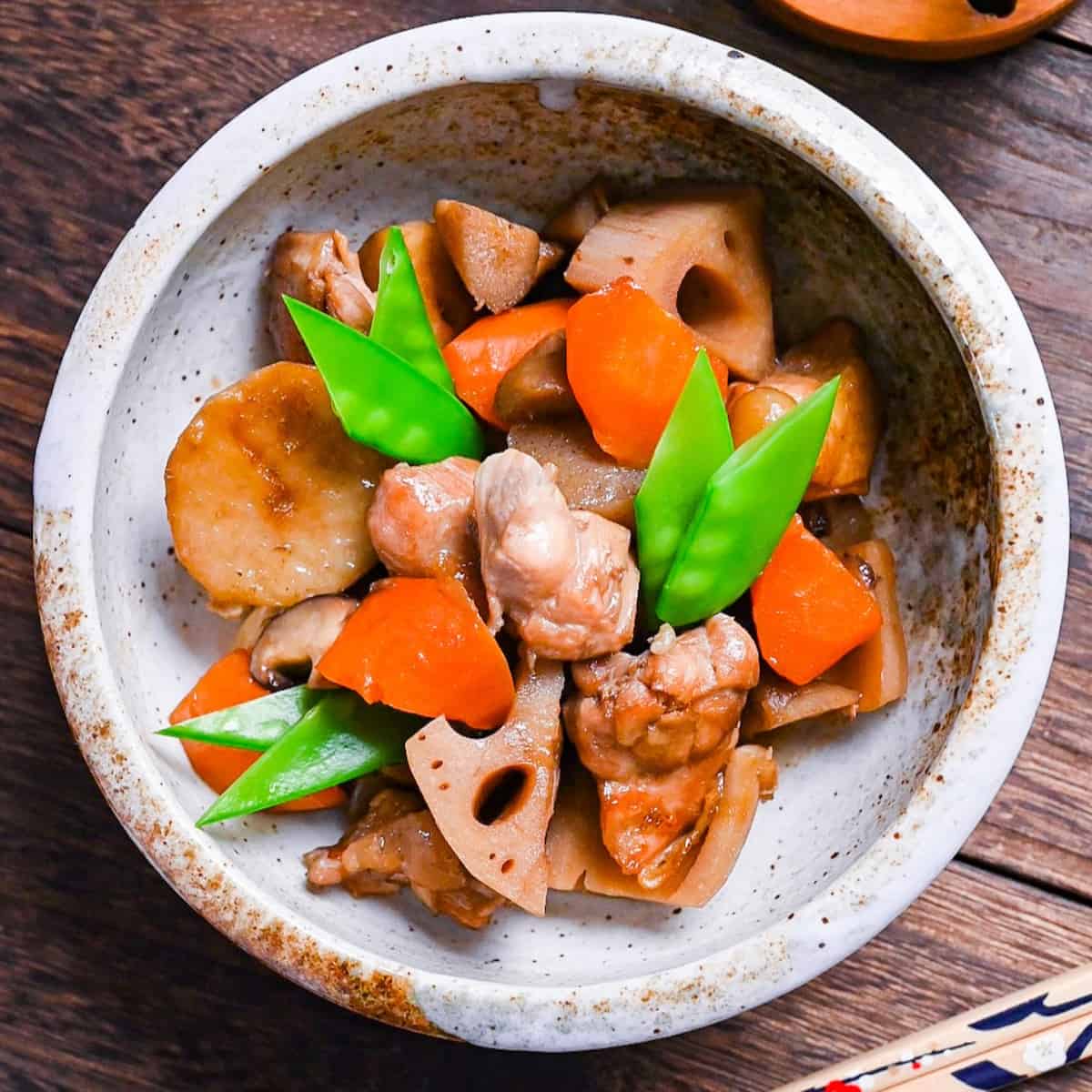 Chikuzenni (Japanese simmered chicken and vegetables) served in a mottled beige bowl