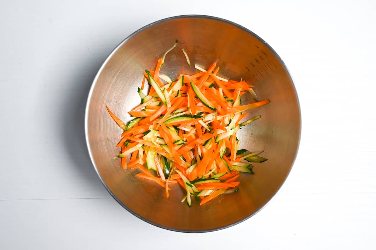 julienned ginger, carrot and cucumber in a steel mixing bowl