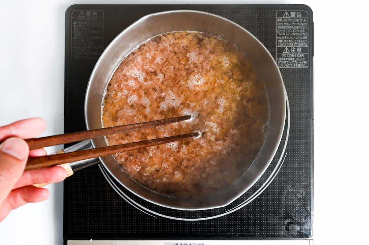 Adding bonito flakes to make dashi