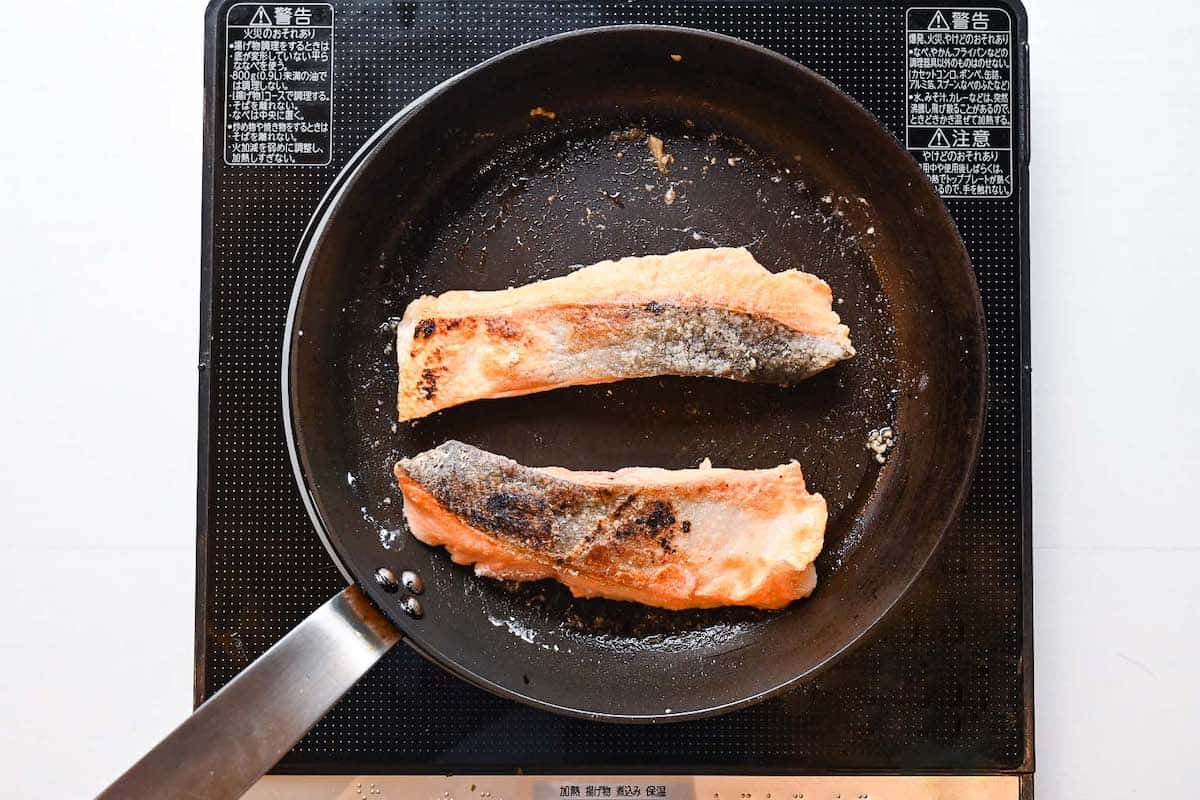 Salmon fillets frying in a pan