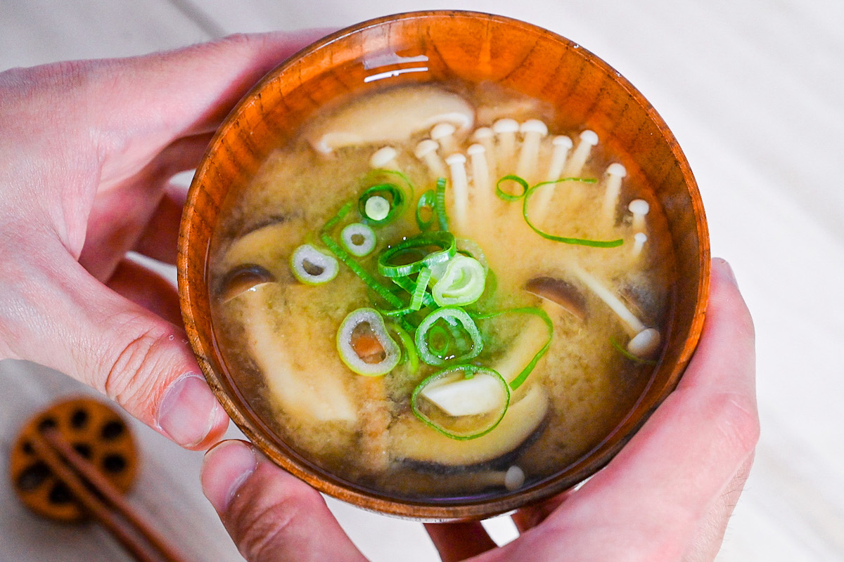 Mushroom miso soup made with 4 kinds of mushroom served in a wooden bowl in hands