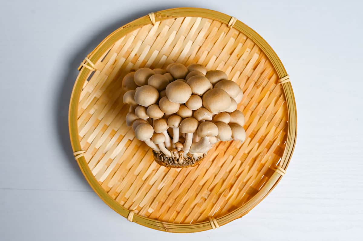 shimeji mushrooms on a round woven bamboo tray