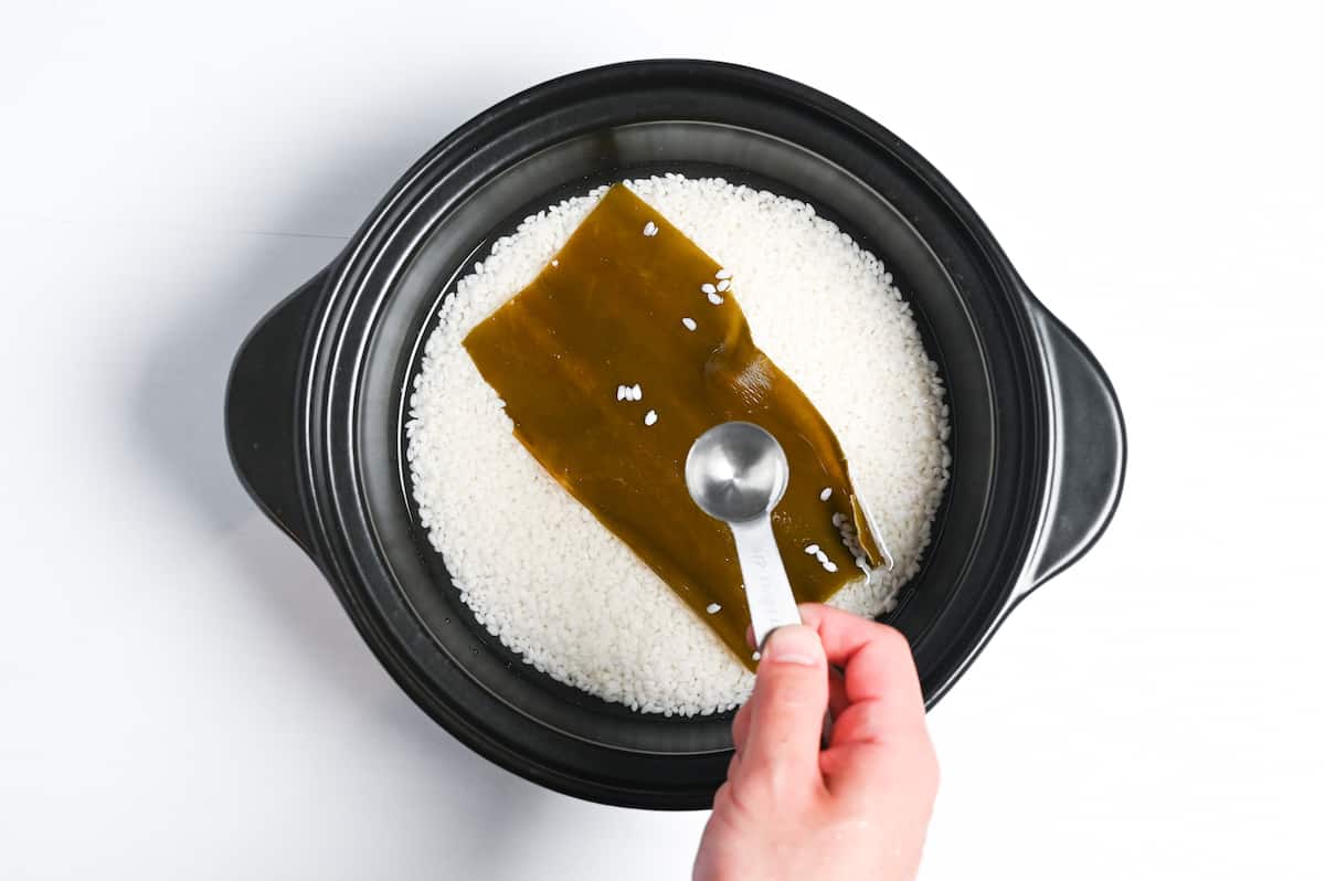 adding sake to pot of rice