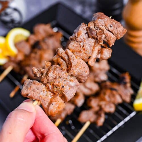 Beef Kushiyaki (Japanese Beef Skewers) served on a black rectangular plate with lemon wedges