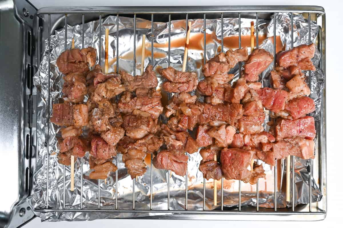 Half cooked beef kushiyaki on a grill