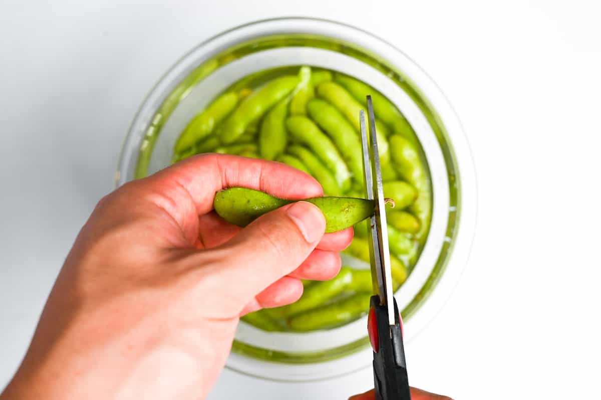 cutting the ends off of fresh edamame