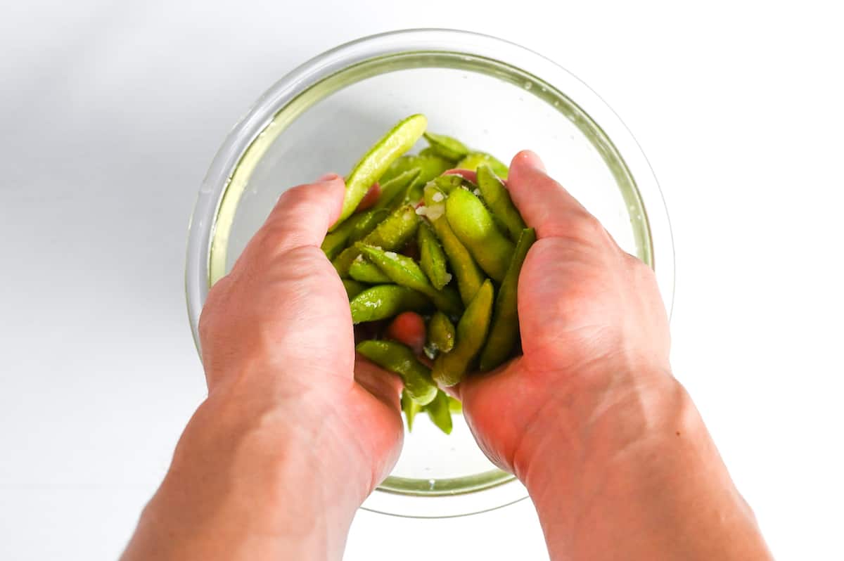 rubbing edamame with salt