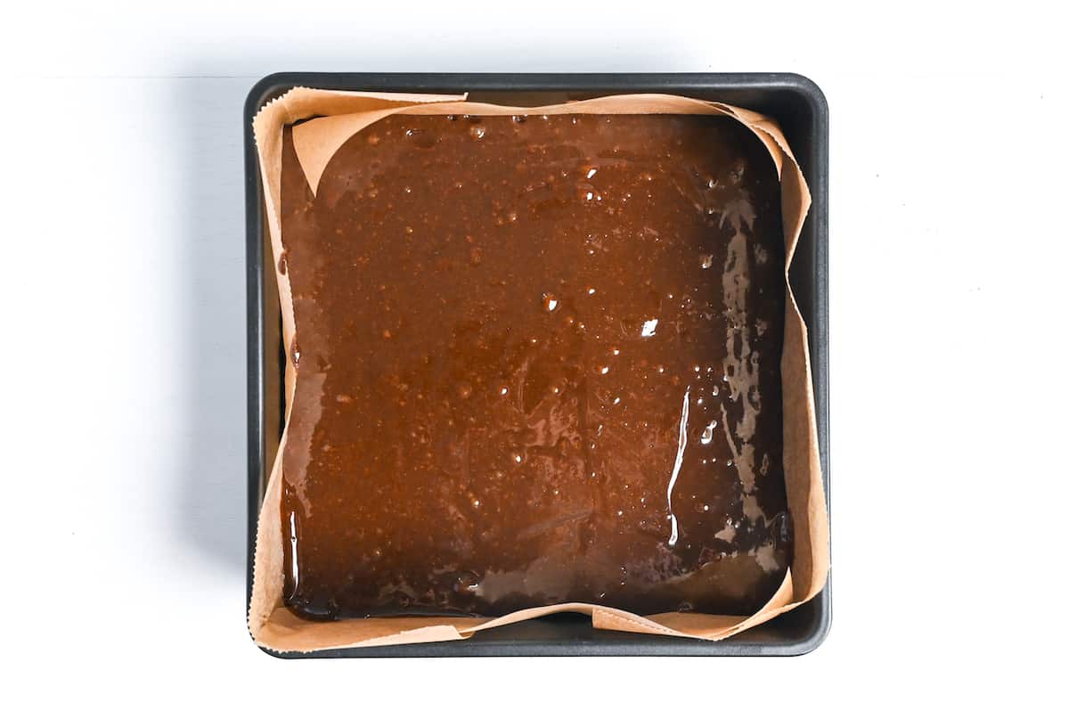 brownie mixture in lined cake pan