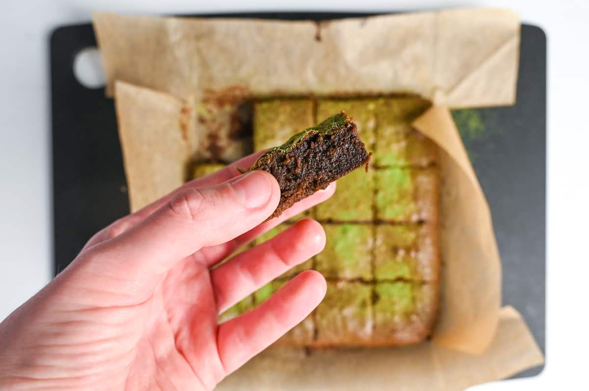 holding one piece of fudgy matcha and dark chocolate brownie