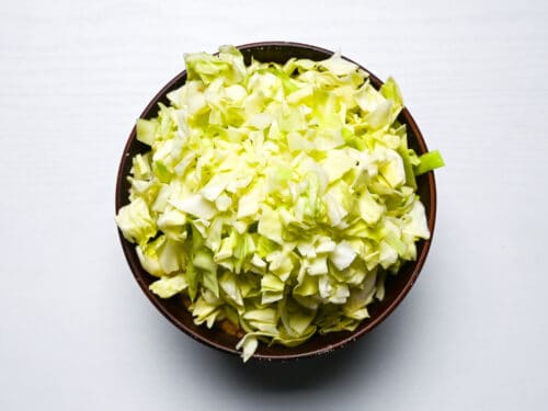 chopped cabbage placed on top of monjayaki batter