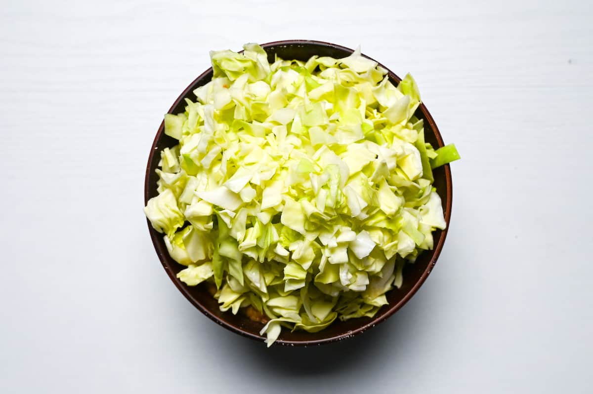 chopped cabbage placed on top of monjayaki batter