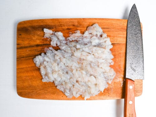finely chopped shrimps on a wooden chopping board