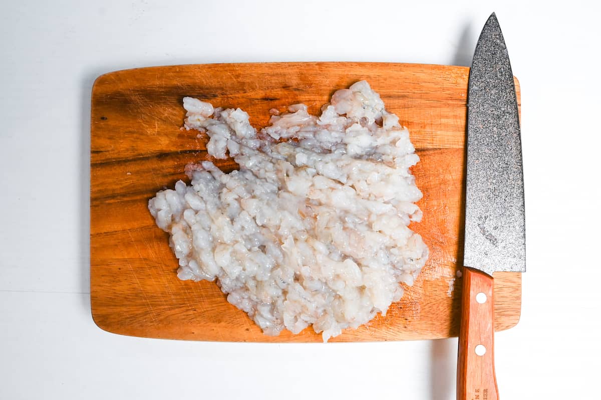 finely chopped shrimps on a wooden chopping board