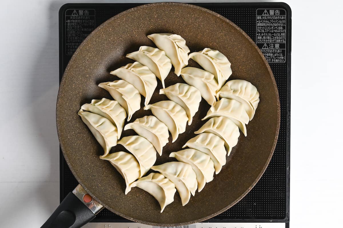 prawn gyoza frying in a pan