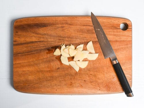 sliced ginger on a wooden chopping board