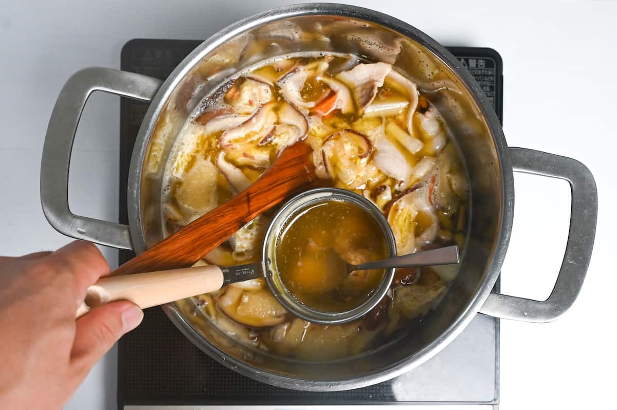 adding first batch of miso paste to tonjiru