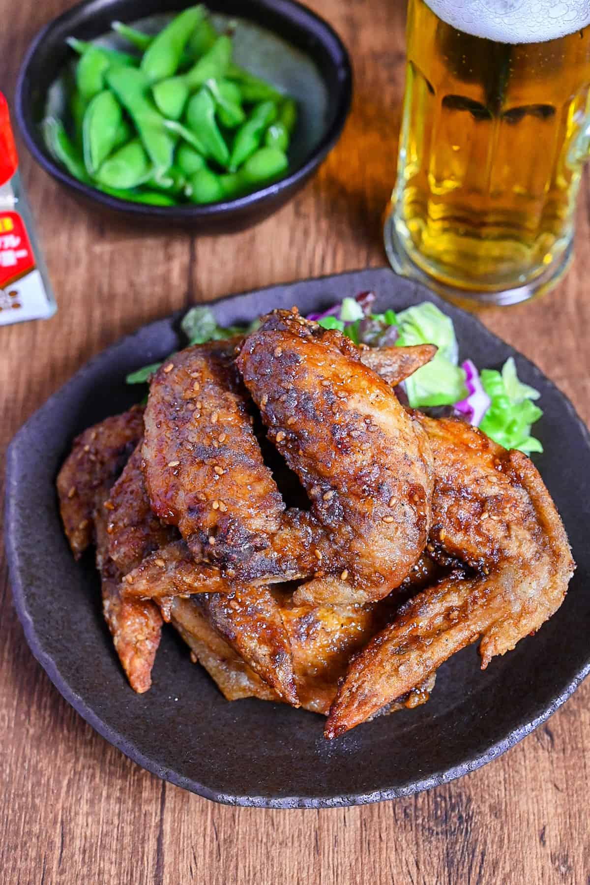 Yamachan Style Fried Chicken Wings (Nagoya Tebasaki) stacked on a dark plate with salad