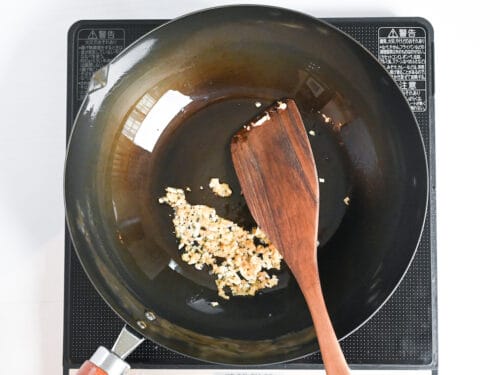 frying finely chopped garlic in a wok