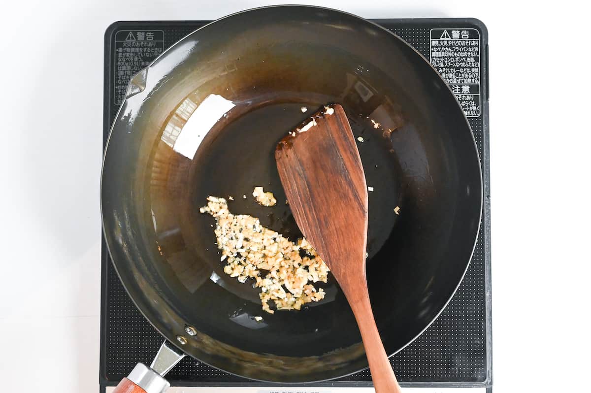 frying finely chopped garlic in a wok