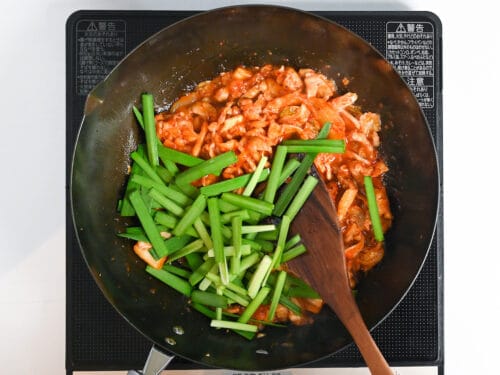 Adding chopped garlic chives to buta kimchi
