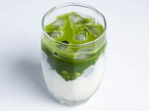 foamy layer of matcha over sweetened milk side view