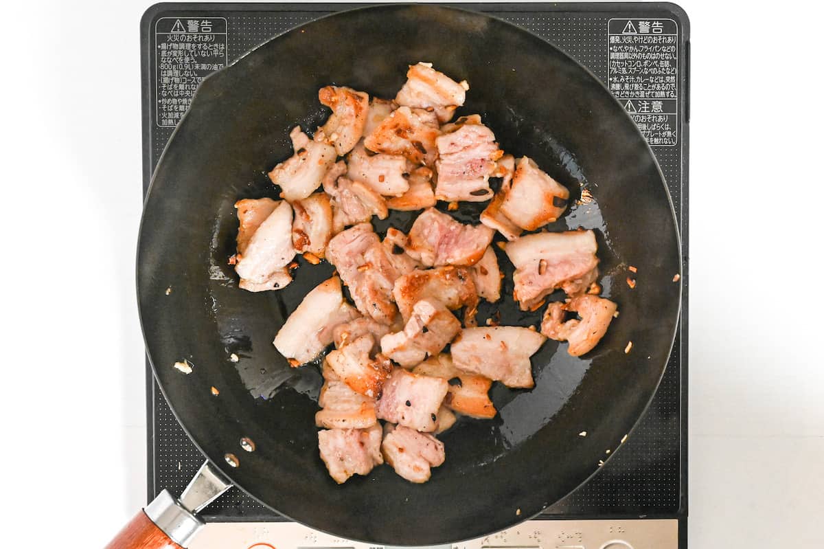 stir frying pork belly in a wok