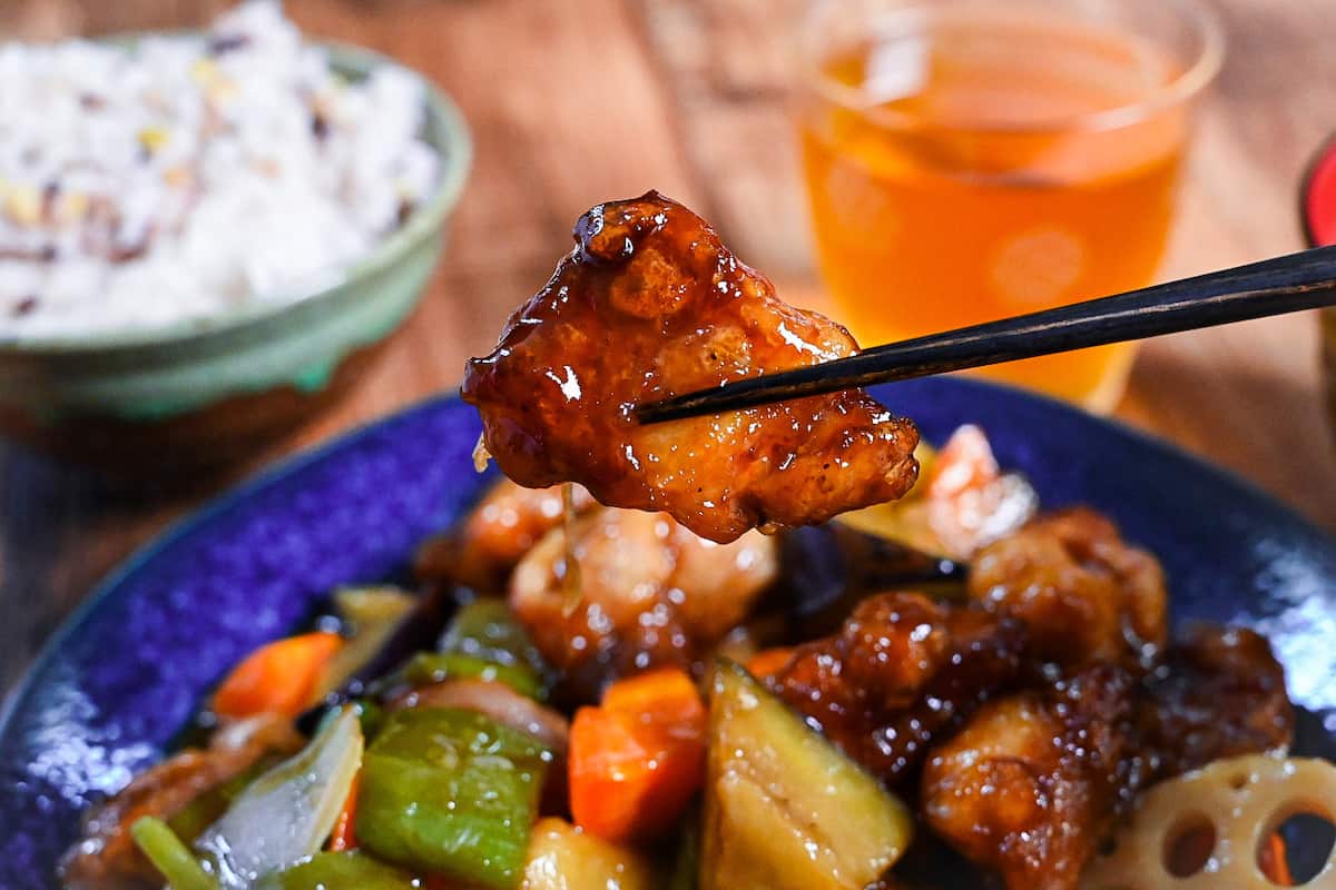 Japanese black vinegar chicken and vegetables (Ootoya style tori to yasai no kurozu an) held with black chopsticks