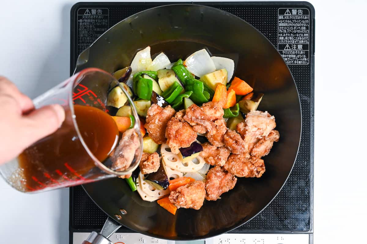 adding kurozu an sauce to vegetables and fried chicken