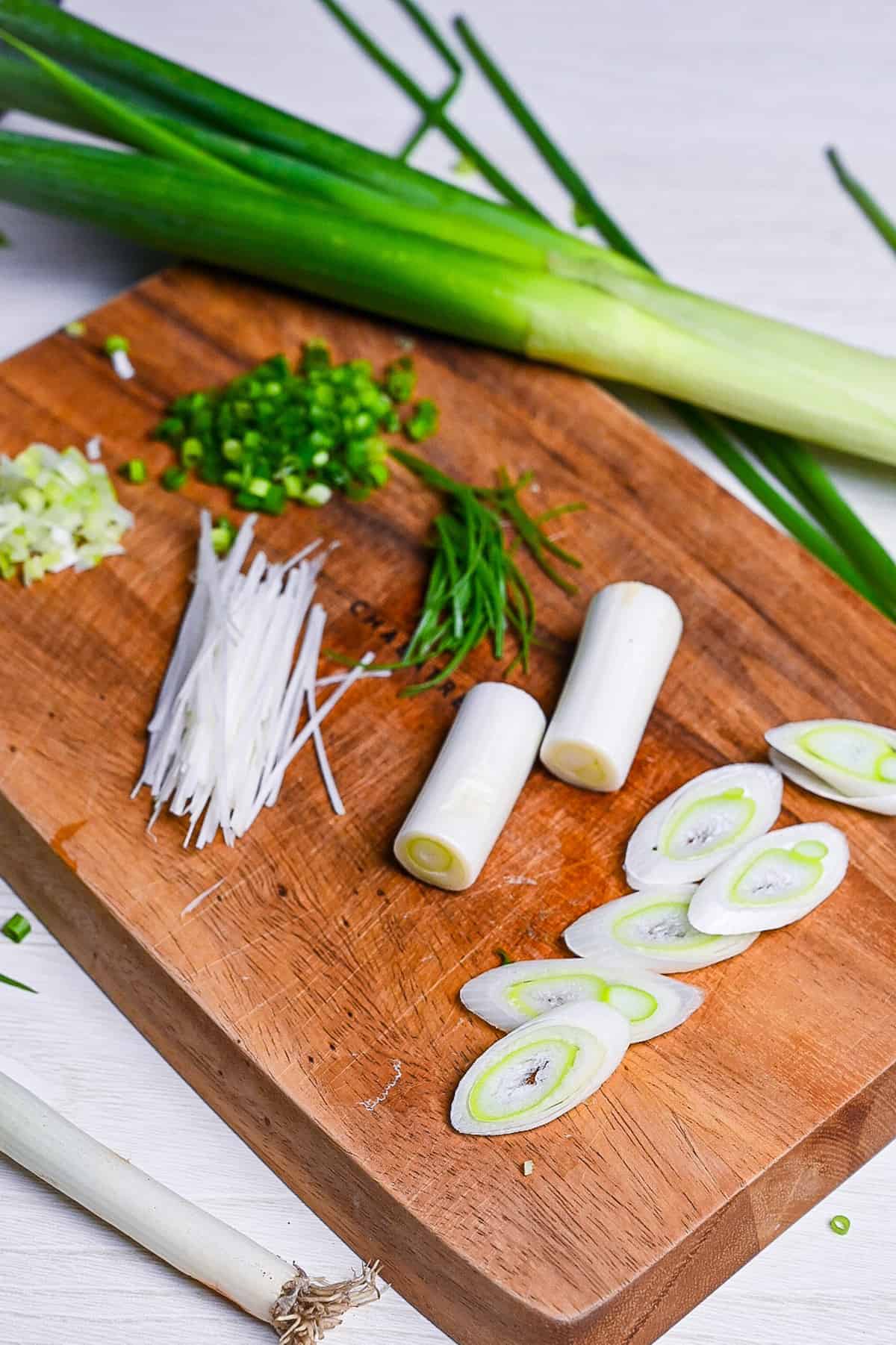 Japanese negi (green onion) cut in various ways on a wooden chopping board