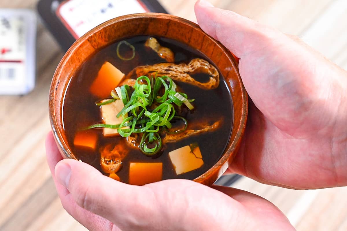 aka-dashi (red miso soup) in wooden bowl topped with chopped green onion