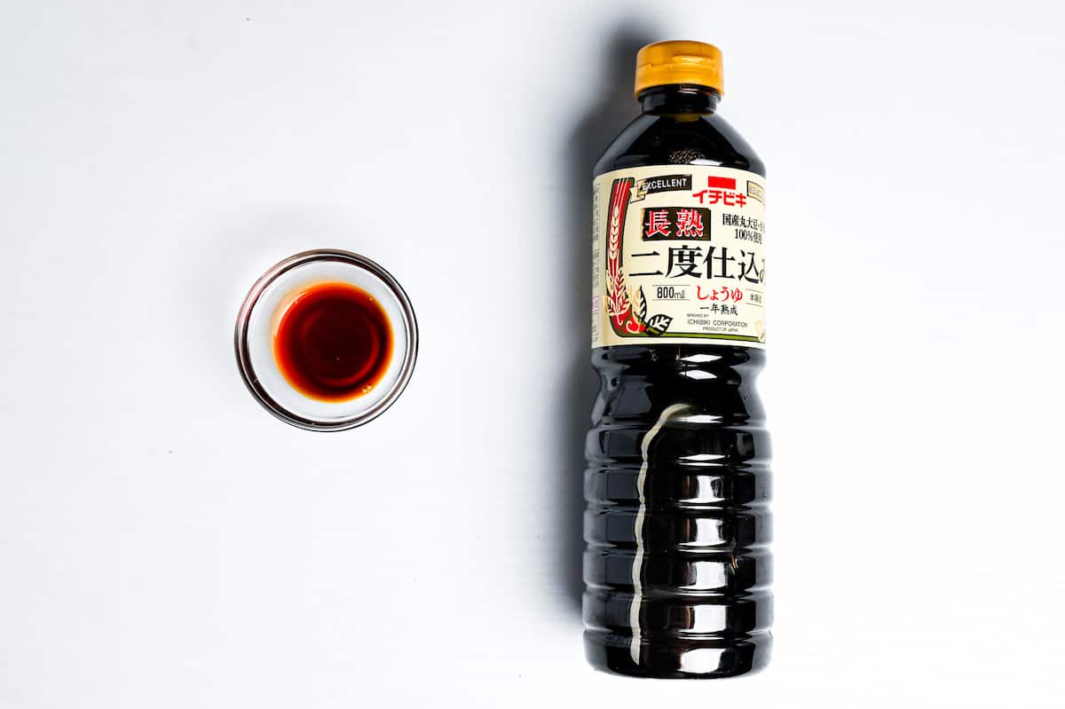 a bottle of ichibiki saishikomi shoyu next to a small amount poured into a glass bowl