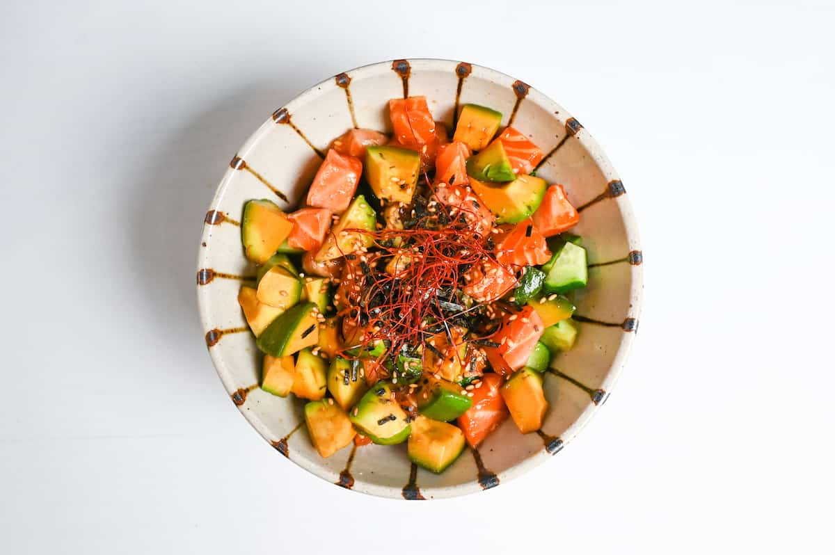 marinated salmon donburi topped with sesame seeds, kizami nori and chili threads.