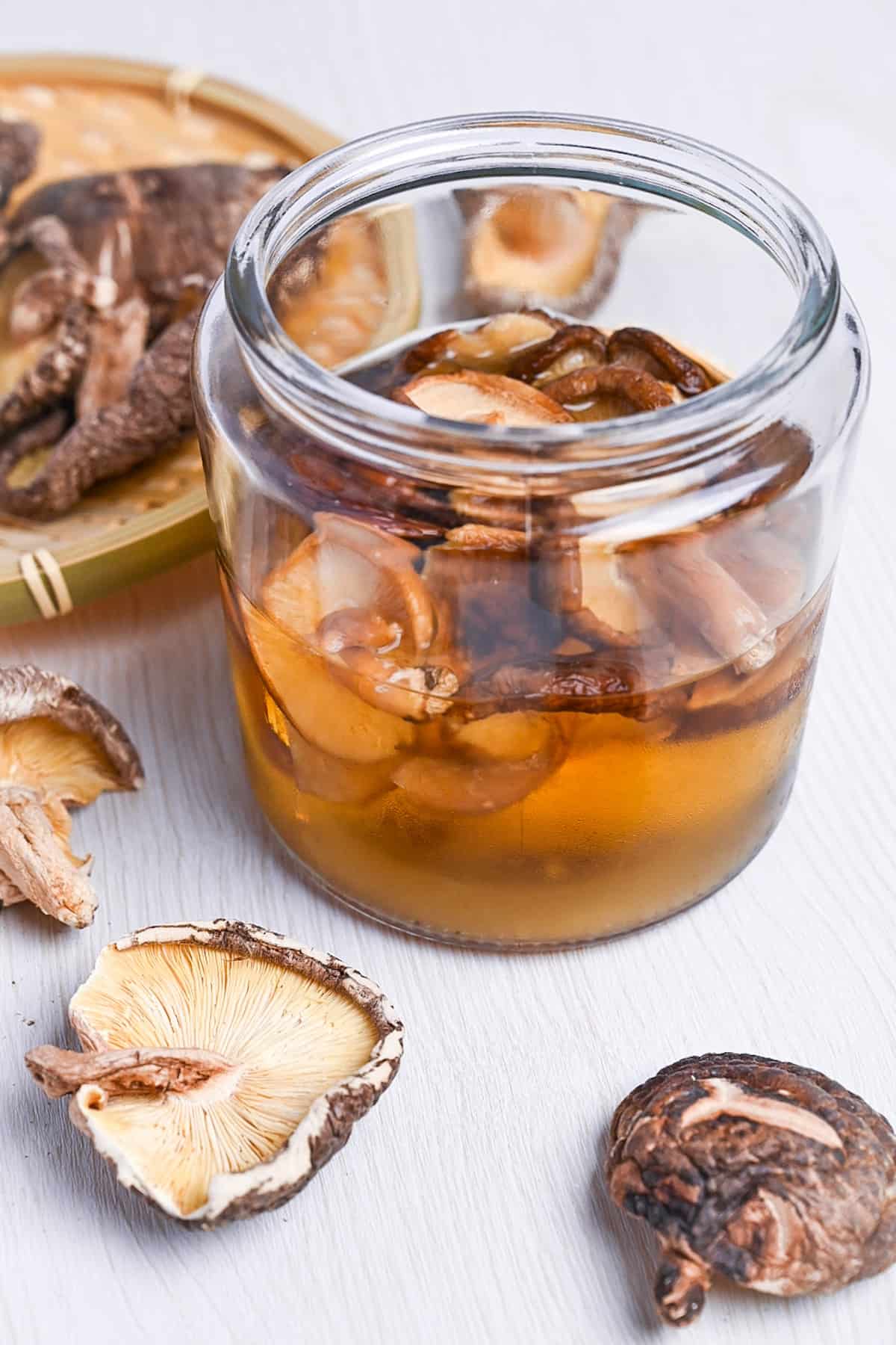 shiitake dashi in a jar next to loose dried shiitake mushrooms