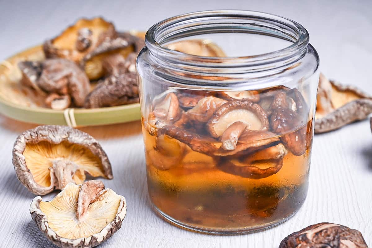 shiitake dashi in a jar next to loose dried shiitake mushrooms