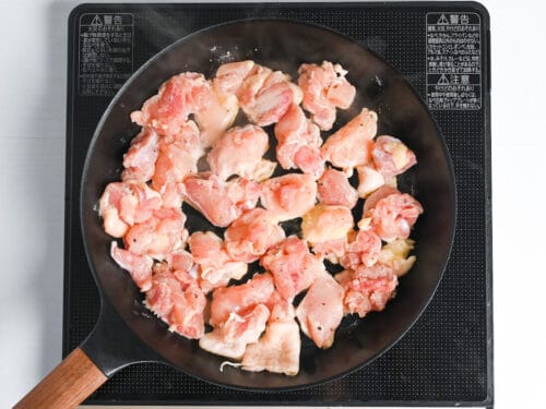 chicken thigh pieces frying in a pan