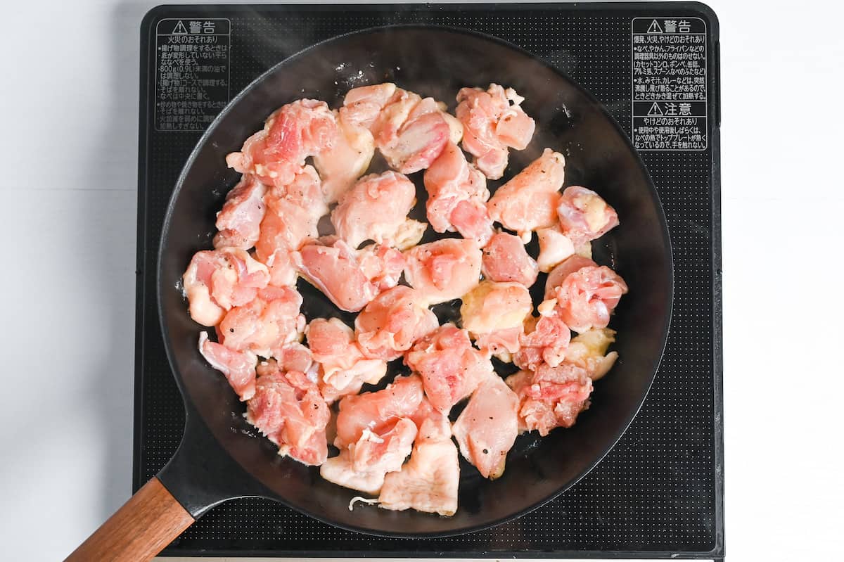chicken thigh pieces frying in a pan