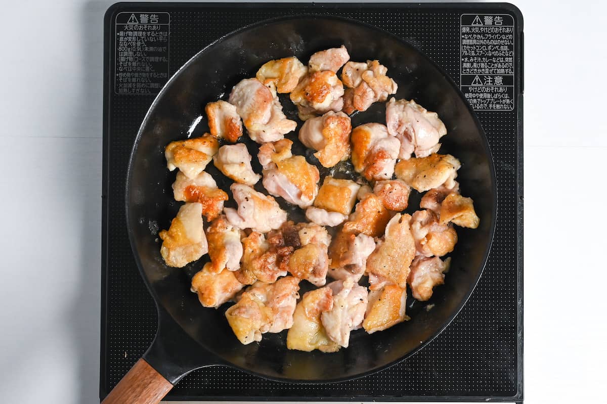 chicken thigh frying in a pan