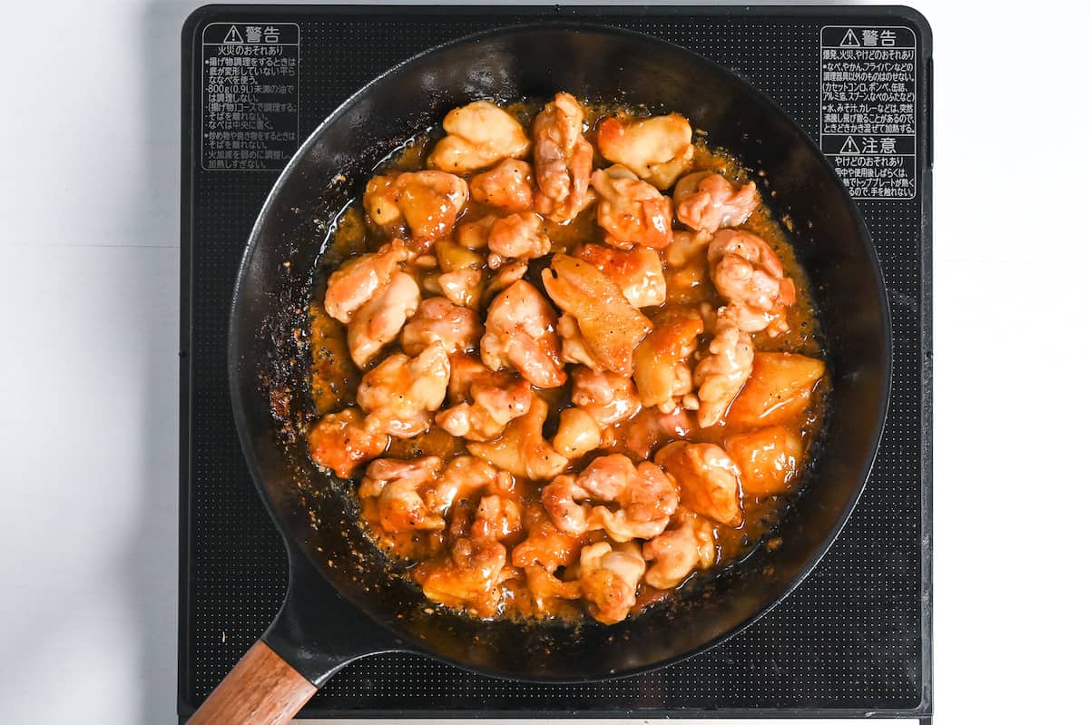 chicken pieces cooking in thickened teriyaki sauce