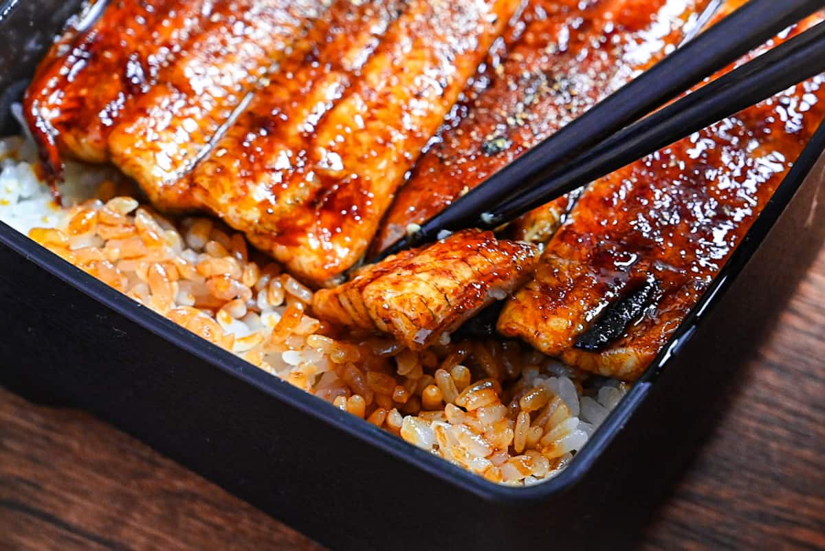 breaking unagi in unaju with black chopsticks