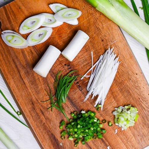 Japanese negi (green onion) cut in various ways on a wooden chopping board