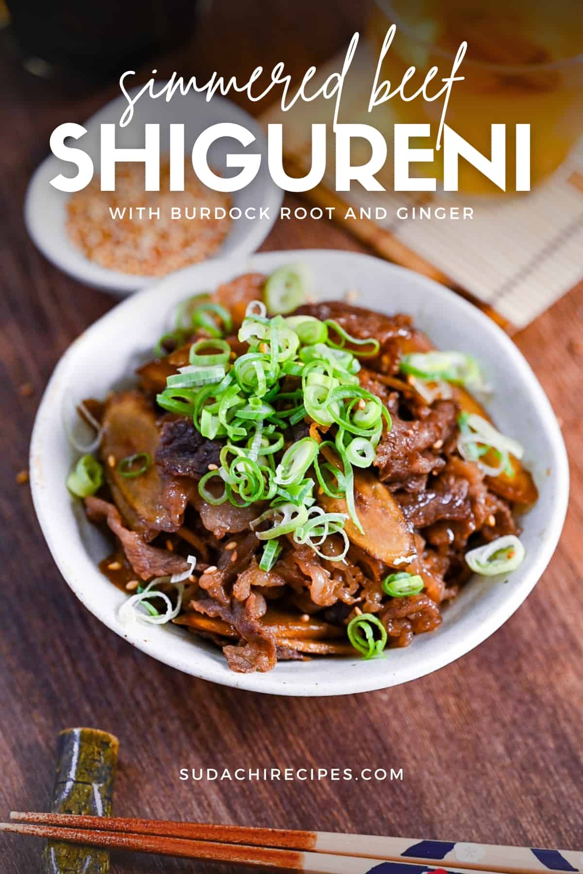 Beef shigureni with ginger and burdock root in a white dish topped with chopped green onion