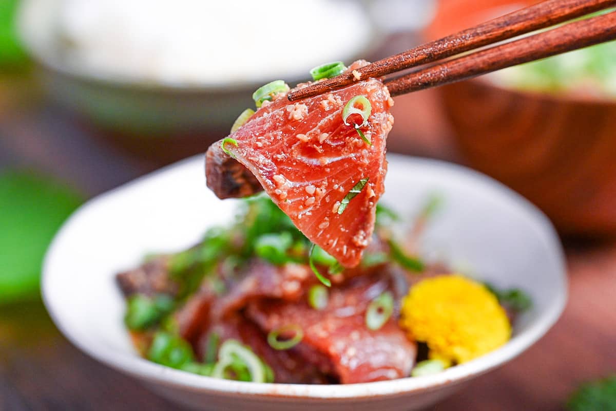 Marinated Yellowtail Sashimi (buri no ryukyu) held with wooden chopsticks