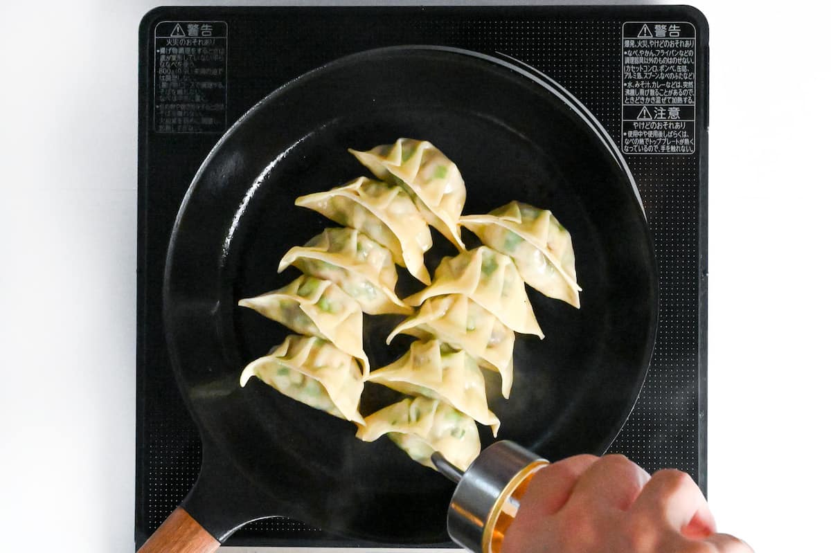 drizzling cooked chicken yaki gyoza with sesame oil