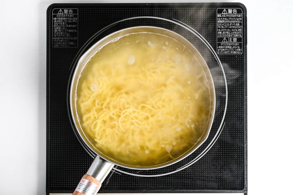 boiling ramen noodles in a pot of water