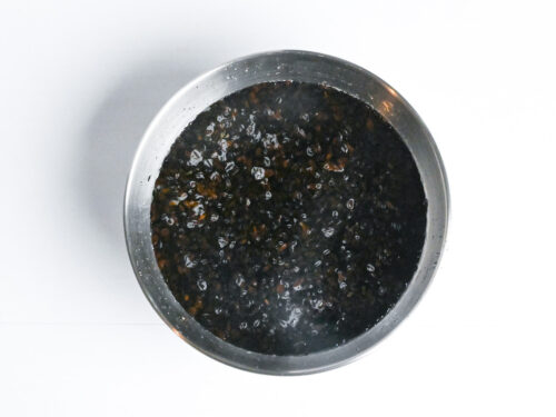 dried hijiki seaweed soaking in a metal mixing bowl filled with water