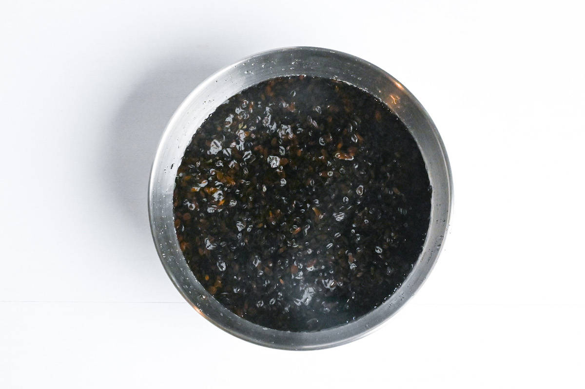 dried hijiki seaweed soaking in a metal mixing bowl filled with water