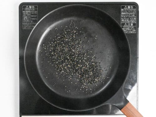 toasting black sesame seeds in a pan