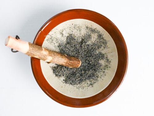 ground black sesame seeds with mortar and pestle
