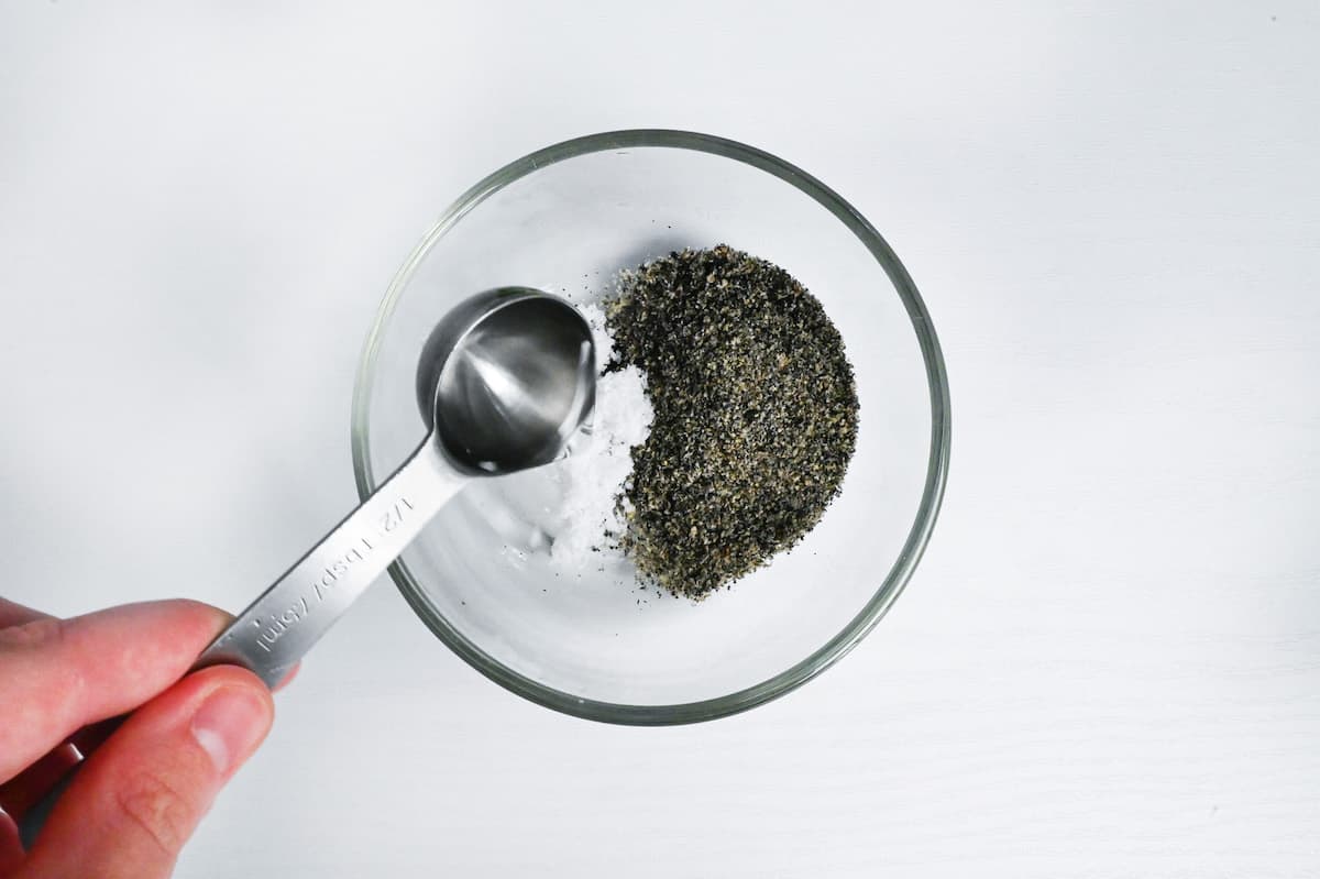 pouring hot water onto ground black sesame seeds and sugar